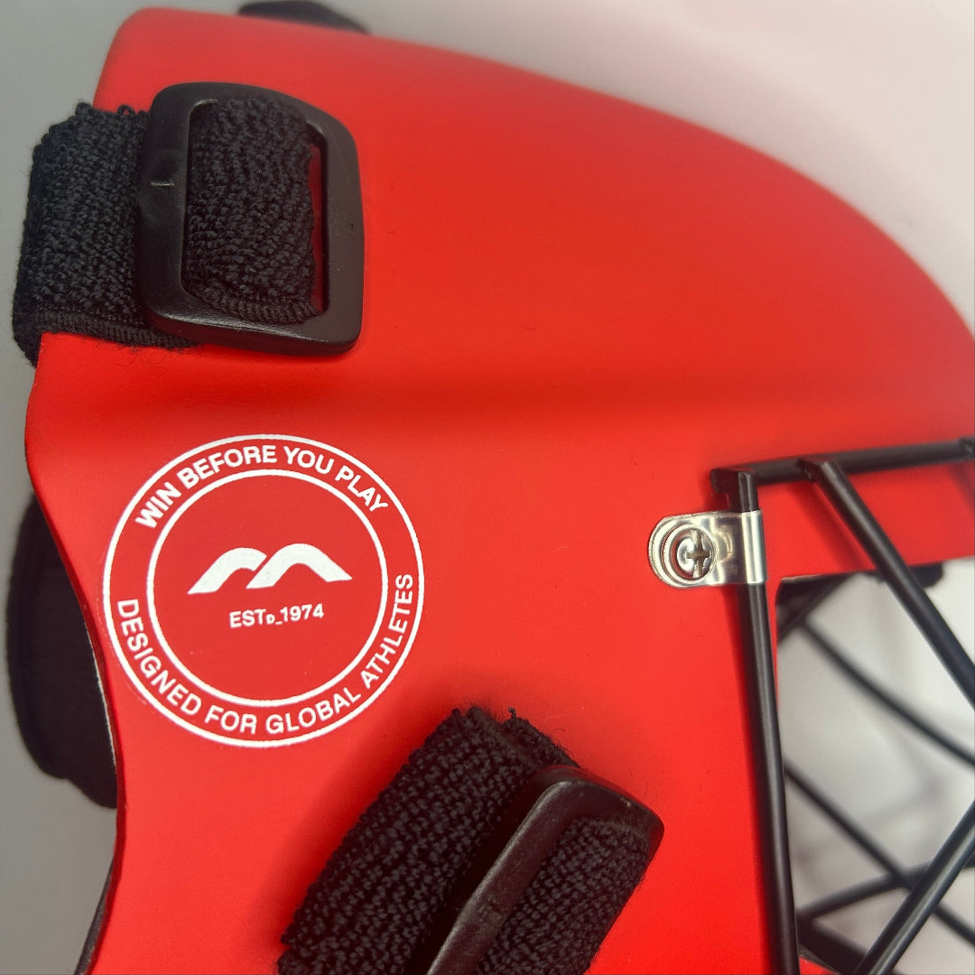 Close-up of a red sports helmet with a logo and text on a blurred background