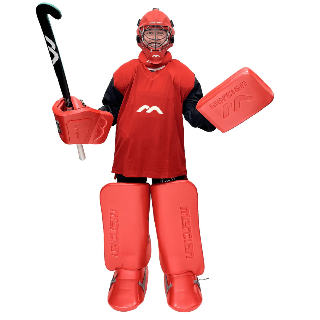 Person wearing red hockey gear with a stick and protective equipment on a white background