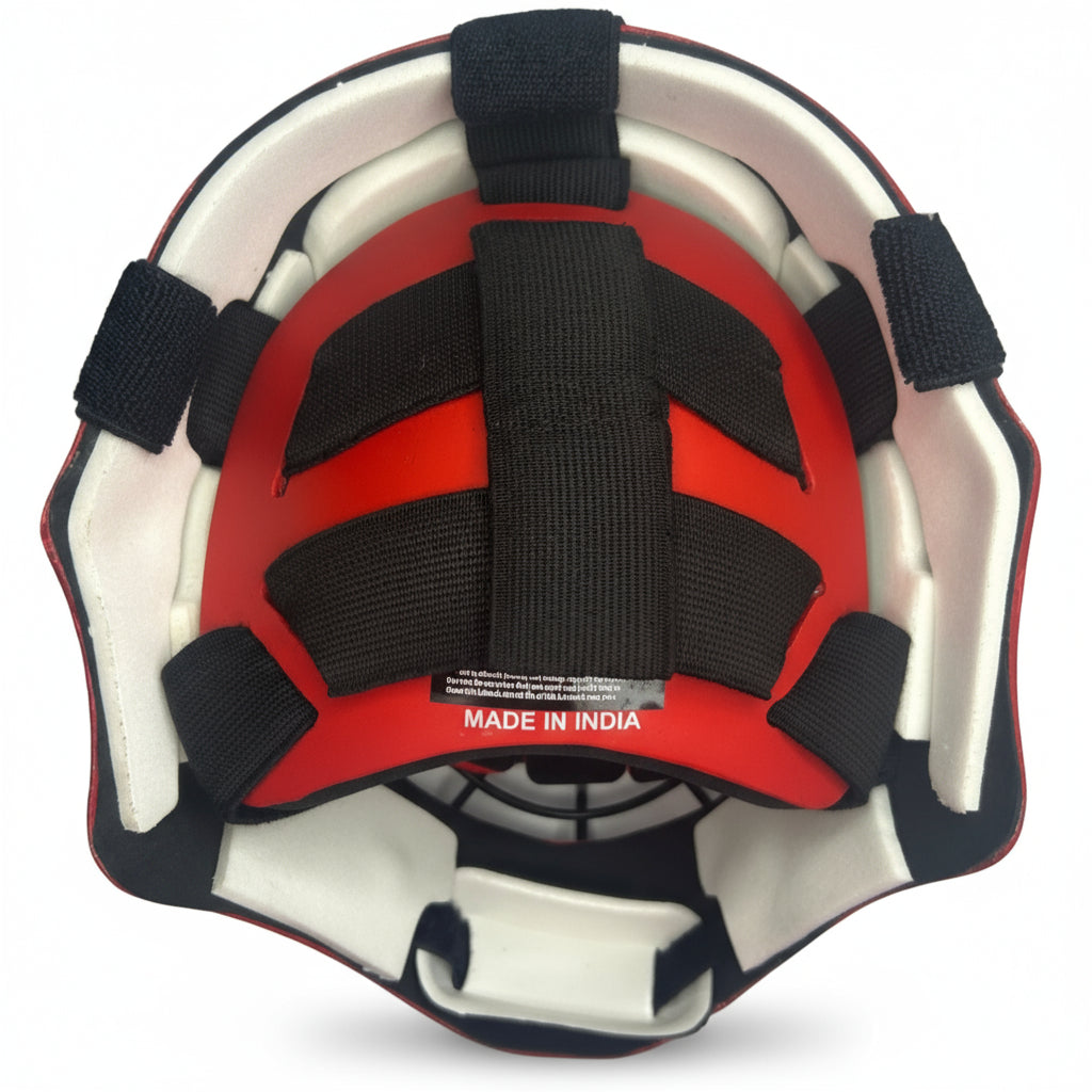 Red field hockey helmet with black straps on a gray background, labeled 'Made in India'.