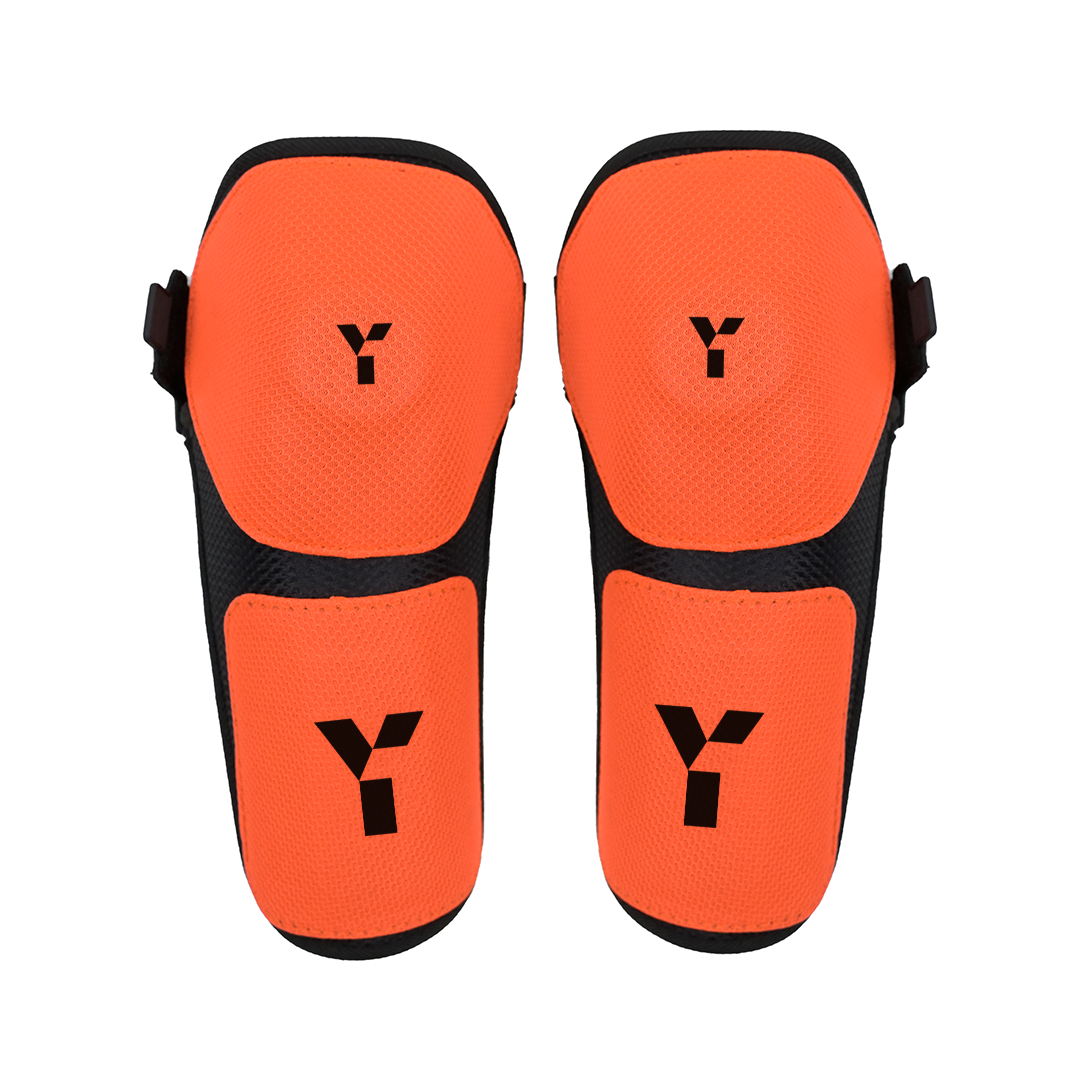 Pair of orange Field Hockey knee guards with black Y logo on a white background
