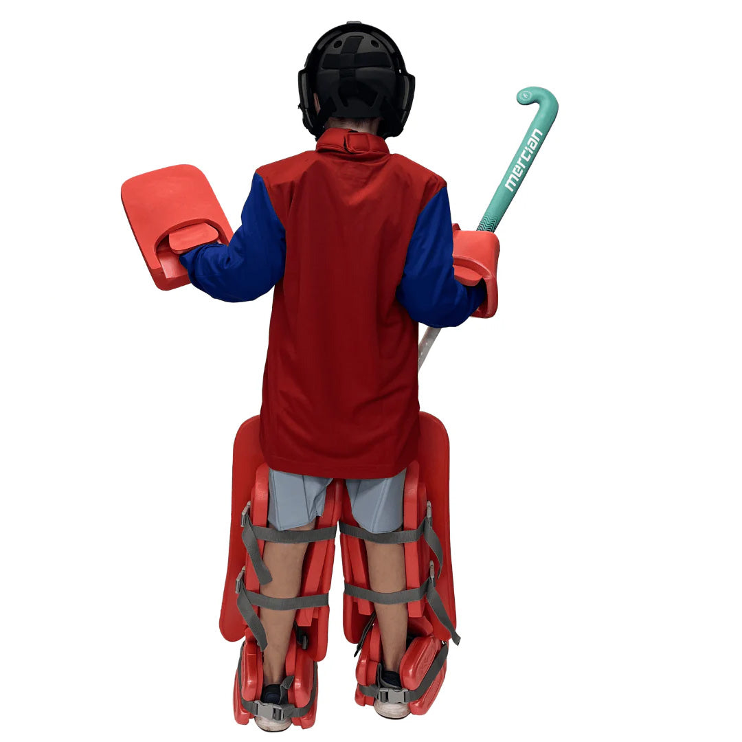 Person wearing a red field hockey jersey, protective gear, and holding a hockey stick on a white background